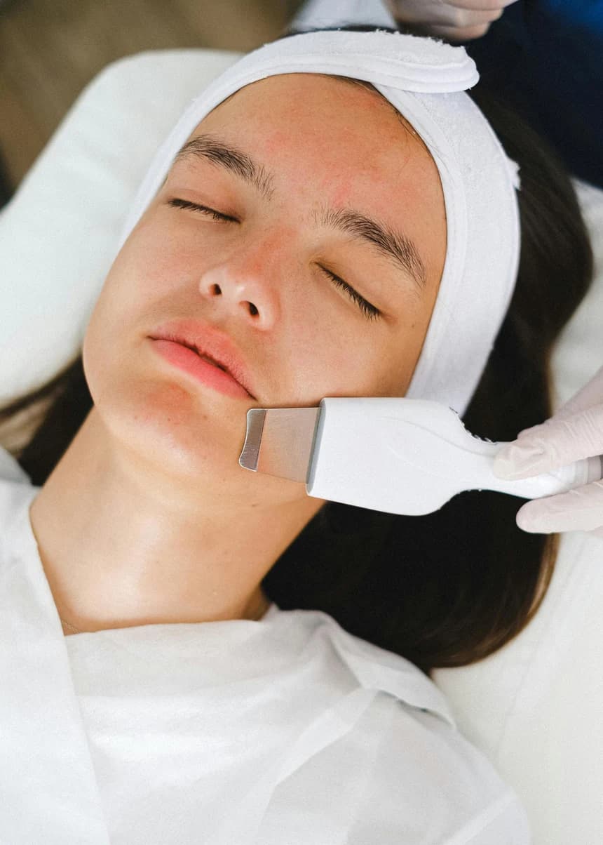 Profissional realizando um cuidado facial em uma cliente na clínica de estética